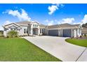 Spacious single-story home with a three-car garage and a well-maintained front yard at 5211 Lake Venice Dr, Wimauma, FL 33598