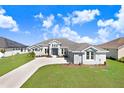 Attractive single-story home with a long driveway and lush green lawn at 5211 Lake Venice Dr, Wimauma, FL 33598