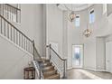 Grand two-story foyer with hardwood floors, decorative lighting, and a staircase with iron railing at 6307 Brevada Ln, Apollo Beach, FL 33572