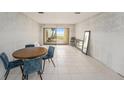 Living room with tiled floors, dining table, and sliding doors to the patio at 7300 Sunshine Skyway S Ln # 108, St Petersburg, FL 33711