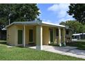 Side view of a house with a covered entry and tidy lawn in a residential neighborhood at 11798 104Th St, Largo, FL 33773