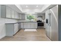 Well-lit kitchen with gray cabinets, stainless steel appliances, and modern flooring at 1415 Ridge Ave, Clearwater, FL 33755