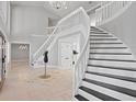 Grand foyer with a winding staircase, travertine tile, and elegant chandelier at 16403 Zurraquin De Avila, Tampa, FL 33613