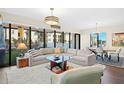 Bright and airy living room with large windows, a plush sofa, area rug, and an adjacent dining area at 199 Dali Blvd # 407, St Petersburg, FL 33701