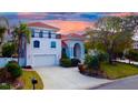 Stunning two-story home with a red tile roof, balcony, and lush tropical landscaping at 301 Midway Is, Clearwater Beach, FL 33767