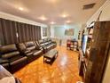 Cozy living room featuring plush leather seating, recessed lighting, and warm, inviting decor at 37634 Hidden Park Ct, Dade City, FL 33525