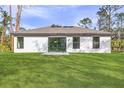A spacious backyard with a well-kept lawn, patio, and large windows at 4621 Kenoska St, North Port, FL 34288