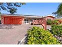 Charming home with lush landscaping, brick driveway, and an eye-catching home number sign at 5166 39Th S St, St Petersburg, FL 33711
