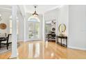 Bright foyer featuring hardwood floors, white columns, and an adjacent office space with hardwood floors at 15005 Lake Emerald Blvd, Tampa, FL 33618