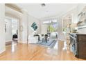 Bright living room featuring hardwood floors, white sofas, a sliding glass door, and views of the outdoor pool area at 15005 Lake Emerald Blvd, Tampa, FL 33618