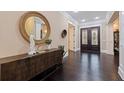 Elegant foyer with dark wood floors, a round decorative mirror, and an entry to the home at 310 8Th N Ave, St Petersburg, FL 33701