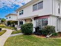 Exterior of condo featuring well-maintained lawn and stone accents at 4352 Tahitian Gardens Cir # E, Holiday, FL 34691