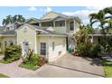 Inviting townhome with a private driveway and a balcony overlooking lush landscaping at 458 Grant St, Dunedin, FL 34698
