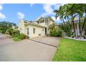 Well-maintained home with a private drive, a covered balcony, and tropical landscaping at 458 Grant St, Dunedin, FL 34698
