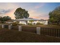 Exterior shot of home with yard as dusk settles around the neighborhood at 13000 Club Dr, Hudson, FL 34667