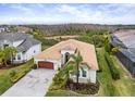 Aerial view of a home featuring a tile roof, brick driveway, and verdant landscaping at 30715 Tumbleberry St, Wesley Chapel, FL 33543