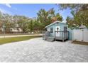 Cozy light blue home featuring a welcoming front porch and a spacious paved driveway at 5161 Rena N St, St Petersburg, FL 33709