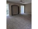 Open living room area featuring neutral paint, carpet and built-in shelving detail at 6769 Breezy Palm Dr, Riverview, FL 33578