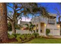 Stunning home featuring a stucco facade, mature landscaping, and charming front porch at 4845 W Sunset Blvd, Tampa, FL 33629