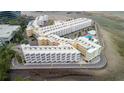 Aerial view of a coastal condominium complex with unique architecture, parking, and a swimming pool at 2506 N Rocky Point Dr # 272, Tampa, FL 33607