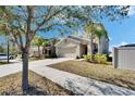 Inviting exterior of a tan two-story home, featuring an attached garage and well-maintained lawn on a sunny day at 6834 Blue Moon Way, Sun City Center, FL 33573