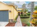 Charming home featuring a brick walkway, lush landscaping, and an inviting front entrance at 5608 Rockfield Loop, Valrico, FL 33596