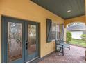 Inviting front porch with decorative glass front doors and a comfortable bench at 5608 Rockfield Loop, Valrico, FL 33596