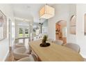 Open-concept dining room with lots of light, a large dining table, and views into the living room and front yard at 924 Landmark S Cir, Tierra Verde, FL 33715