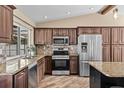 Well-equipped kitchen with dark cabinetry, stainless steel appliances, granite counters, and decorative backsplash at 11001 Hobson St, Spring Hill, FL 34608
