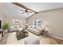 Spacious living room with vaulted ceiling, wood beam, neutral decor, and plenty of natural light at 11001 Hobson St, Spring Hill, FL 34608