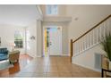 Bright foyer featuring tile flooring, high ceilings, staircase, and views to the entry door and sitting room at 587 Lakewood Dr, Oldsmar, FL 34677