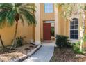 Inviting front entrance with manicured landscaping, stone-lined walkway, and a vibrant red door with sidelight window at 587 Lakewood Dr, Oldsmar, FL 34677