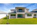 Home's backyard with ample green space, a covered patio, and a second story balcony overlooking the yard at 8421 Golden Beach Ct, Parrish, FL 34219