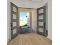 Inviting entryway featuring stylish double doors and elegant wood flooring at 8421 Golden Beach Ct, Parrish, FL 34219