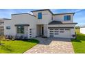 Beautiful home featuring modern architecture, a two-car garage, stone accents, and well-manicured landscaping at 8421 Golden Beach Ct, Parrish, FL 34219