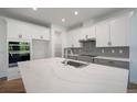 Modern kitchen boasts two-tone cabinetry, large island with a sink, and stainless steel appliances at 11892 Richmond Trl, Parrish, FL 34219