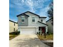 Two-story home with a two-car garage, red door, and manicured lawn in a residential neighborhood at 13456 Marble Sands Ct, Hudson, FL 34669