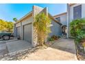 Townhouse exterior with a two-car garage, walkway, and manicured landscaping at 6320 Grand Bahama Cir # 6320, Tampa, FL 33615