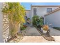 Charming home with stone pathway leading to arched entryway surrounded by lush, tropical landscaping at 6320 Grand Bahama Cir # 6320, Tampa, FL 33615