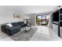 Bright living room featuring a large sectional sofa, area rug, and scenic water views through sliding glass doors at 6320 Grand Bahama Cir # 6320, Tampa, FL 33615