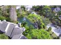 Picturesque aerial view of a home next to a pond with a fountain and mature trees in a quiet neighborhood at 103 Old Mill Pond Rd, Palm Harbor, FL 34683