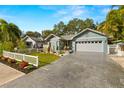 Charming single-story home featuring a two-car garage, a well-manicured lawn, and a welcoming, landscaped entrance at 1030 Charles St, Clearwater, FL 33755