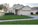 Well-maintained home featuring a lush green lawn, clean sidewalk, and a spacious two-car garage at 9551 Jaybird Ln, Land O Lakes, FL 34638