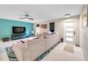 Bright living room featuring a comfortable couch, modern ceiling fan, and lots of natural light at 1753 Lucas Dr, Clearwater, FL 33759