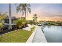 Waterfront backyard with lush tropical landscaping, a private dock, and direct water access at 5809 Cruiser Way, Tampa, FL 33615
