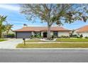 Inviting single-story home with a tile roof, a two-car garage, and a beautifully landscaped front yard at 5809 Cruiser Way, Tampa, FL 33615