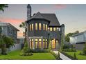 Charming two-story home showcasing stone accents, a well-manicured lawn at sunset at 807 W Park Ave, Tampa, FL 33602