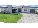 Single Gathering home exterior with a well manicured lawn and a modern garage door and minimalist landscaping at 8347 Golden Beach Ct, Parrish, FL 34219