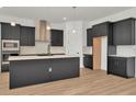 This kitchen has stainless steel appliances, a modern range hood, and dark modern cabinetry at 8347 Golden Beach Ct, Parrish, FL 34219