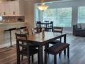 Bright dining room with wood floors and open floor plan, complemented by a view to the living room with lots of windows at 907 Knollwood Dr, Dunedin, FL 34698